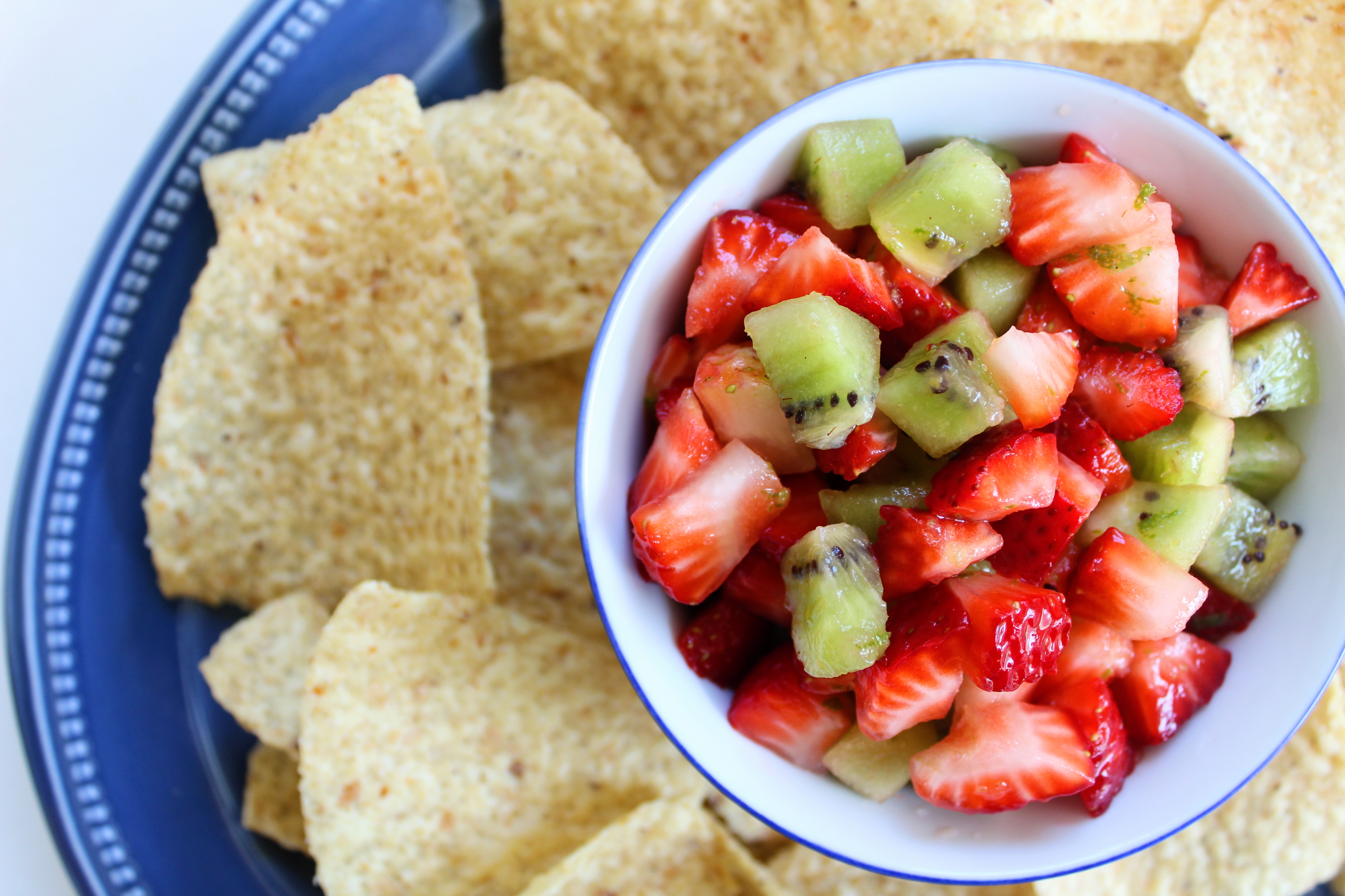 Fresh strawberries and kiwi are chopped and dressed in lime juice to make a simple homemade fruit salsa to serve with tortilla chips.