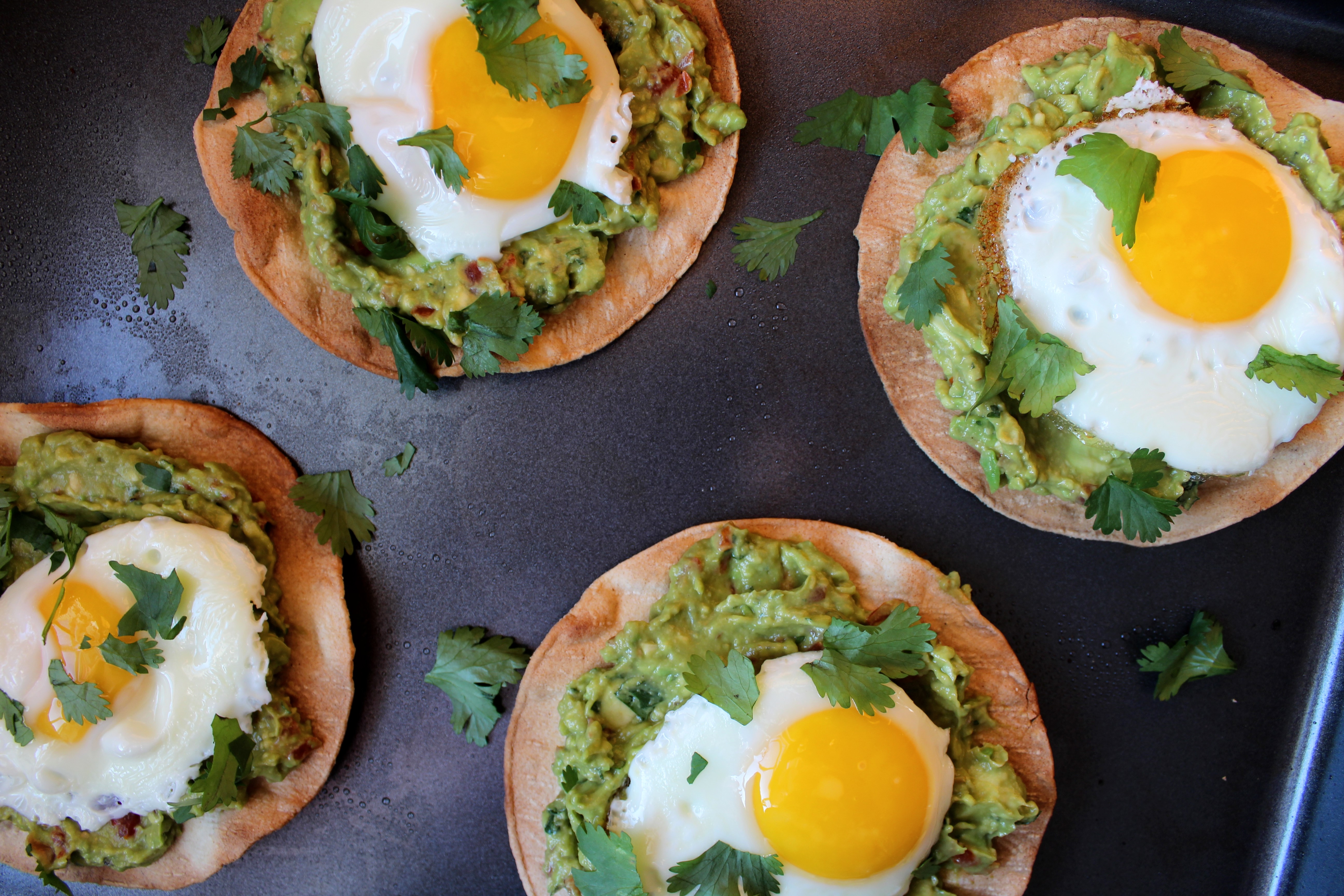 Avocado Breakfast Tostadas - Crispy, oven-baked tortillas topped with fresh guacamole and fried eggs